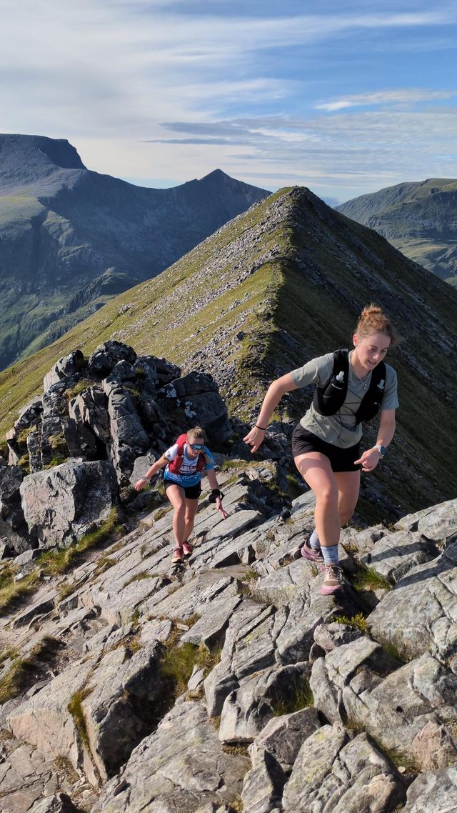 Two runners scrambling along the Ring of Steall ridge